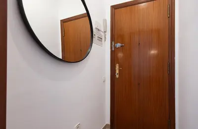 a bathroom with a mirror and a wooden door at Stay U-nique Apartments Sant Nicolau in Barcelona