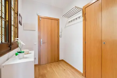 a room with a hallway with a wooden door at Flateli Pelayo H3 in Barcelona
