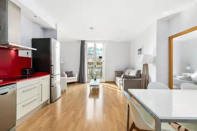 a kitchen and living room with a table and chairs at Flateli Pelayo H3 in Barcelona