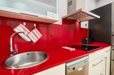 a kitchen with a sink and a red counter top at Flateli Pelayo H3 in Barcelona