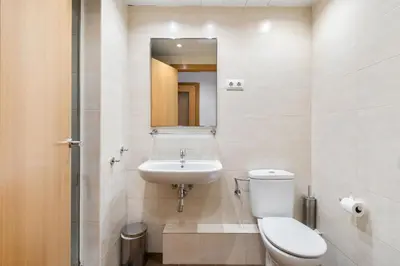 a bathroom with a toilet and a sink and a mirror at Flateli Pelayo H2 in Barcelona