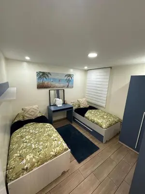 a room with two beds and a table with a picture at Alojamiento Entero Moderno En Barcelona Terrassa in Terrassa