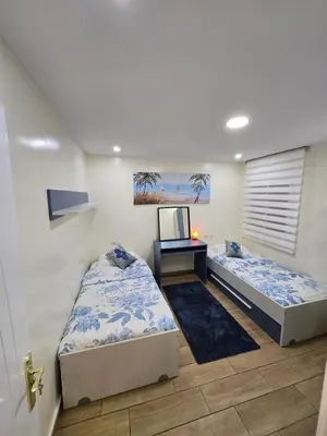 two beds in a room with a desk and a tv at Alojamiento Entero Moderno En Barcelona Terrassa in Terrassa