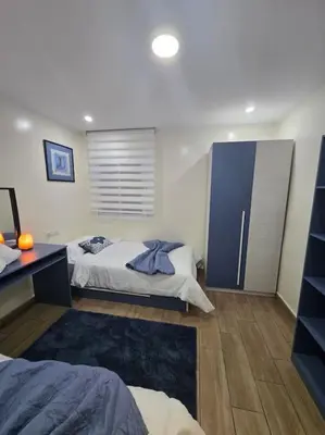 a bedroom with two beds and a blue cabinet at Alojamiento Entero Moderno En Barcelona Terrassa in Terrassa