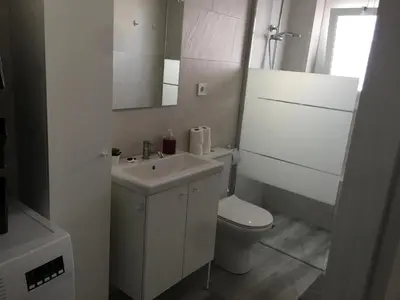 a white bathroom with a toilet and a sink at Loft espectacular vista al mar in Sitges