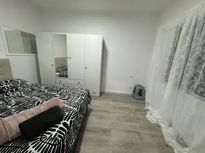 a bedroom with a black and white bed and a mirror at Habitacion Sagrada Familia in Barcelona