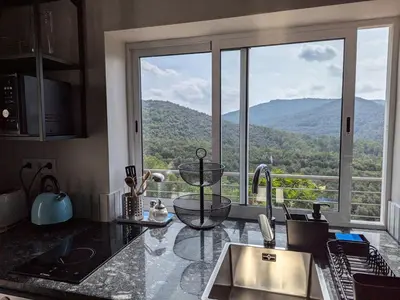 a kitchen with a large window with a mountain view at Apartamento en medio de la naturaleza, con fantásticas vistas in Sant Cugat del Vallès