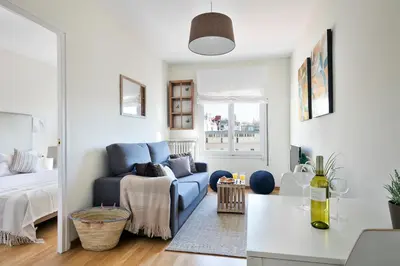 a living room with a blue couch and a bed at Stay U-nique Apartments Rambla Catalunya in Barcelona