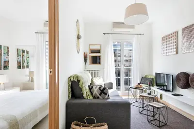 a bedroom with a bed and a chair and a tv at Stay U-nique Apartments Rambla Catalunya in Barcelona
