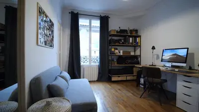 a living room with a couch and a desk with a computer at Bien en exclusivité in El Prat de Llobregat