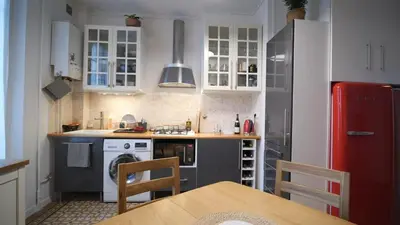 a kitchen with white cabinets and a red refrigerator at Bien en exclusivité in El Prat de Llobregat