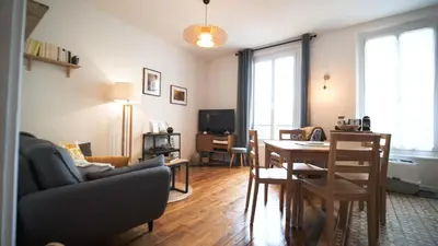 a living room with a couch and a table and a dining room at Bien en exclusivité in El Prat de Llobregat