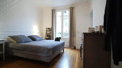 a bedroom with a bed with a cat sitting on it at Bien en exclusivité in El Prat de Llobregat