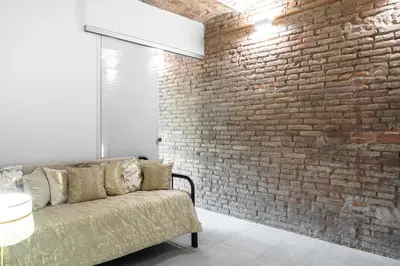 a living room with a brick wall and a couch at Magic Apartment with Private Terrace in Barcelona