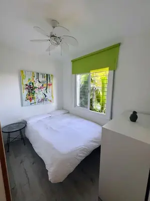 a bedroom with a white bed and a window at Casa con piscina uso privado in Cunit