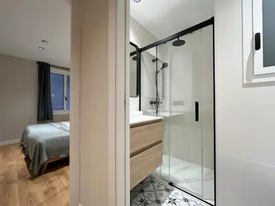 a bathroom with a shower and a sink and a bed at Stay U-nique Apartment Castanyer in Barcelona