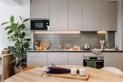 a kitchen with a wooden table and a kitchen with white cabinets at Casa Ciudadela in Barcelona