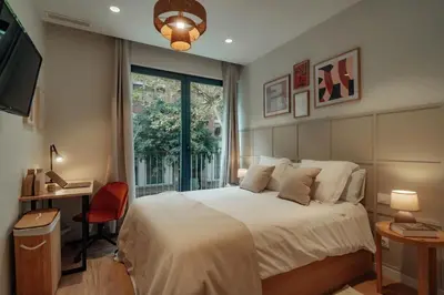a bedroom with a bed and a desk and a window at Casa Carlit - 1 bedroom apartment near Plaza Tetuán in Barcelona
