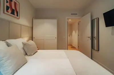 a bedroom with a large white bed and a closet at Casa Carlit - 1 bedroom apartment near Plaza Tetuán in Barcelona