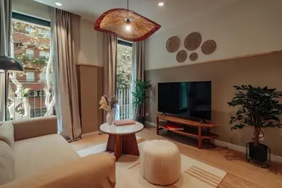 a living room with a couch and a tv at Casa Carlit - 1 bedroom apartment near Plaza Tetuán in Barcelona
