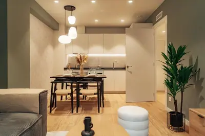 a living room with a table and a kitchen at Casa Castaner in Barcelona