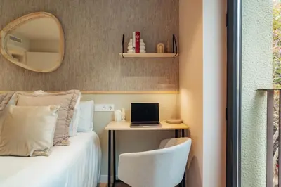 a bedroom with a bed and a desk with a laptop at Casa Castaner in Barcelona