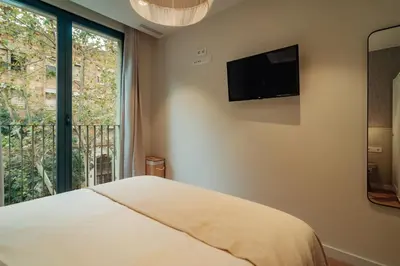 a bedroom with a bed and a large window at Casa Castaner in Barcelona