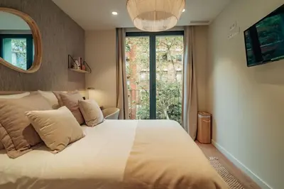 a bedroom with a large white bed with a window at Casa Castaner in Barcelona