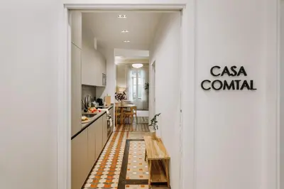a hallway leading to a kitchen with a table in it at Casa Comtal in Barcelona