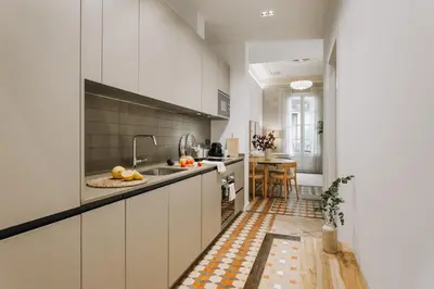 a kitchen with white cabinets and a table in it at Casa Comtal in Barcelona