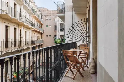 a balcony with two chairs and a table on it at Casa Comtal in Barcelona