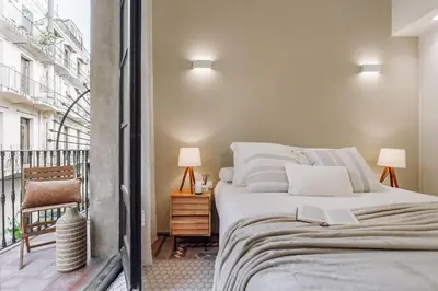 a bedroom with a large bed and a balcony at Casa Comtal in Barcelona