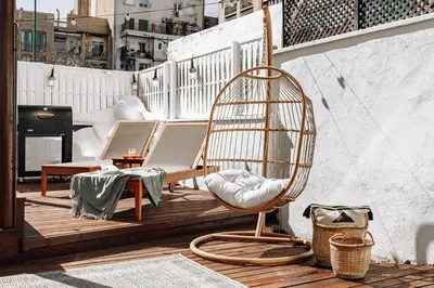 a rattan chair on a balcony with a piano at Casa Narciso in Barcelona