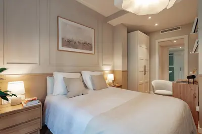 a bedroom with a large white bed and a chair at Casa Dorada in Barcelona