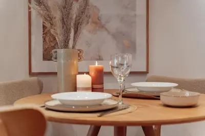 a wooden table with a candle and plates and glasses at Casa Dorada in Barcelona