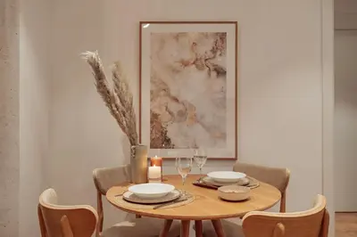 a dining room table with a candle and a painting at Casa Dorada in Barcelona