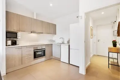 a kitchen with white cabinets and a stove top oven at Enrique Granados Apartment in Barcelona