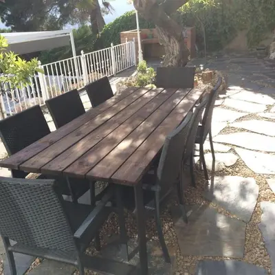 a wooden table with chairs around it on a patio at House Seaviews Barcelona 22Km in Cabrils