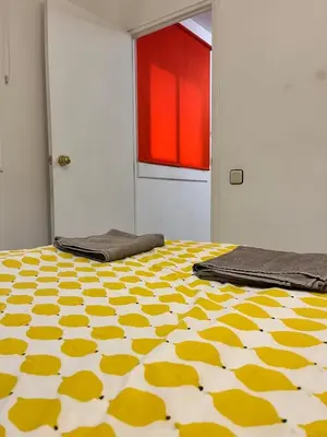 a bedroom with a yellow and white floor with a window at Triumf in Barcelona