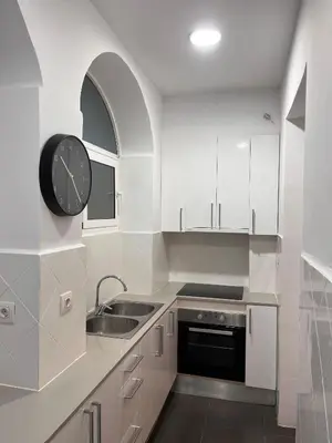 a kitchen with a sink and a clock on the wall at MAB1 - Apartamento a pie de calle con terraza privada in Barcelona