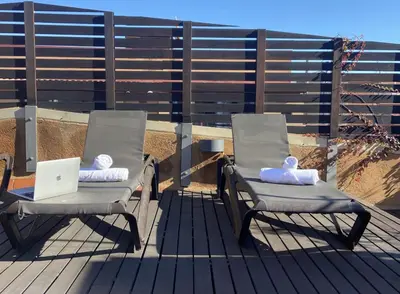 two chairs sitting on a deck with a laptop at MAB1 - Apartamento a pie de calle con terraza privada in Barcelona