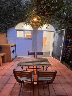 a picnic table and two chairs in a patio at MAB1 - Apartamento a pie de calle con terraza privada in Barcelona