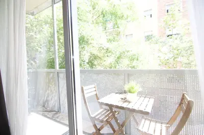 a table and chairs on a balcony with a window at Glasir Homes Barcelona in Barcelona