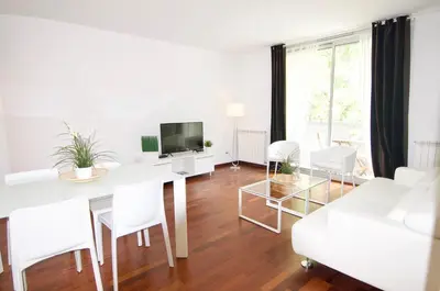 a white living room with a white table and white chairs at Glasir Homes Barcelona in Barcelona