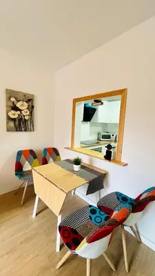 a living room with a table and chairs and a mirror at MaiFamilyBCN-Cómodo Y Para familia Y Metro Cercano in Badalona