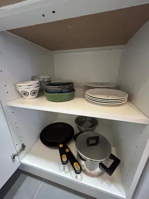 a white cabinet with plates and utensils in it at MaiFamilyBCN-Cómodo Y Para familia Y Metro Cercano in Badalona