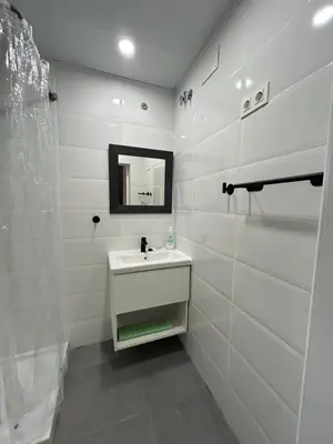 a white bathroom with a sink and a mirror at MaiFamilyBCN-Cómodo Y Para familia Y Metro Cercano in Badalona