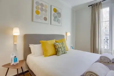 a bedroom with a large white bed with yellow pillows at Sant Joan entresol in Barcelona