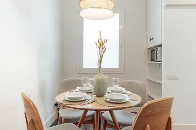 a dining room table with chairs and a vase at Casa Gavina in Barcelona