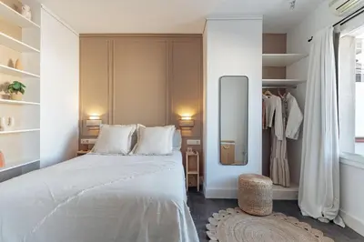 a bedroom with a large white bed and a mirror at Casa Gavina in Barcelona